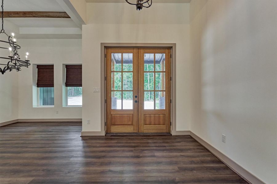 The dining area with wood beam accents is situated to the right of the front door