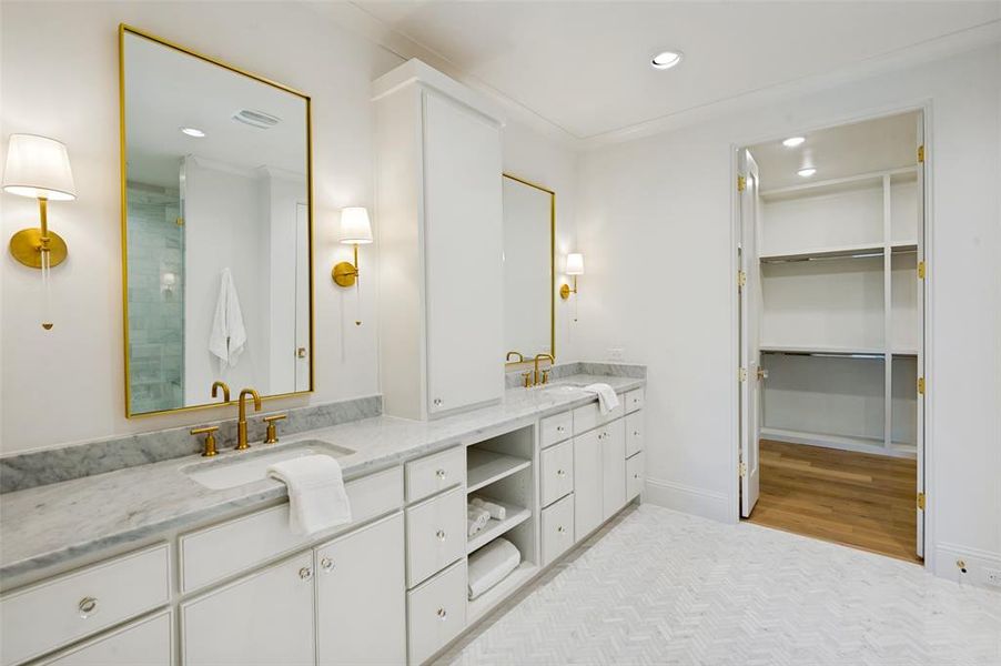 Bathroom featuring a dual vanity with undermount sinks, marble countertops, and gold-finish fixtures