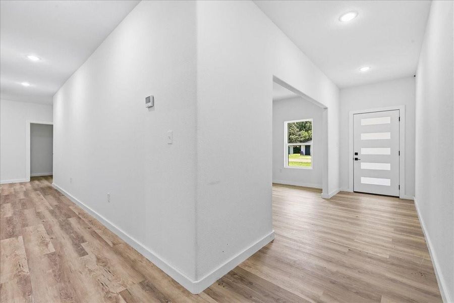 Step inside to a bright, open foyer featuring durable wood-look flooring and clean white walls. Step inside to a bright, open foyer featuring durable wood-look flooring and clean white walls.