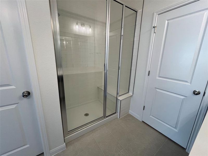 Large oversized walk-in shower with quartz bench