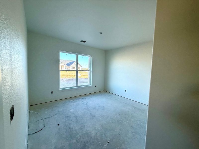 Unfurnished room featuring unfinished concrete flooring Unfurnished room featuring unfinished concrete flooring