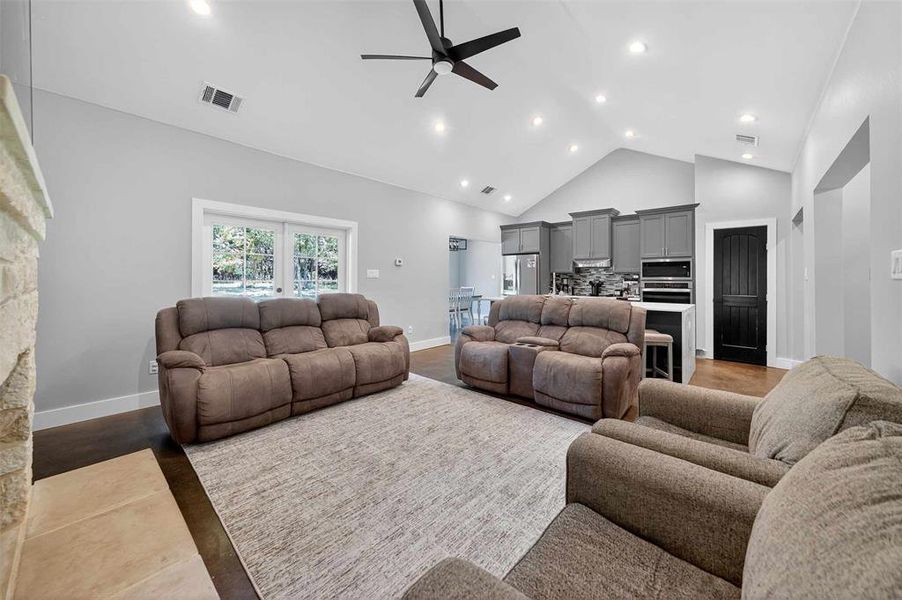 Living area with high vaulted ceiling, a ceiling fan, recessed lighting, and light wood-style floors Living area with high vaulted ceiling, a ceiling fan, recessed lighting, and light wood-style floors