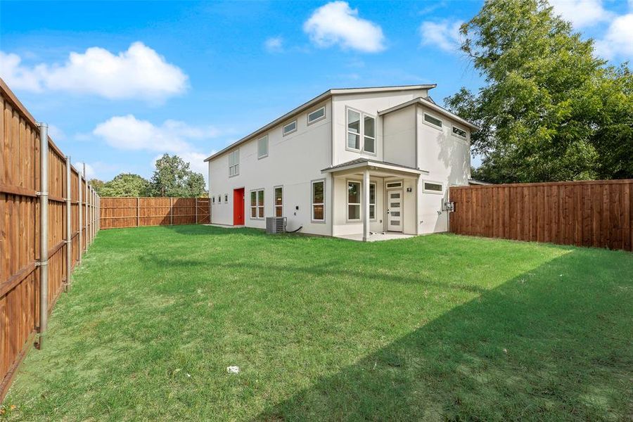Rear view of house featuring a patio area, stucco siding, and a fenced backyard