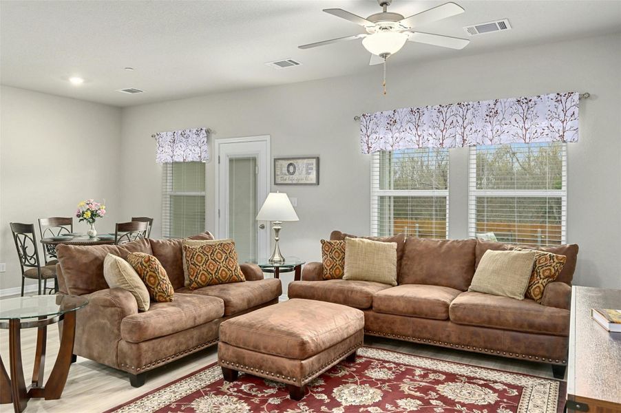 Living room featuring light wood-type flooring and ceiling fan