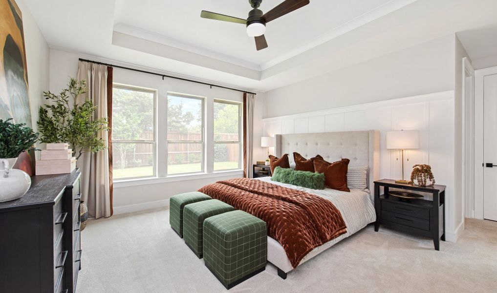 Primary suite with decorative feature wall and plush carpeting