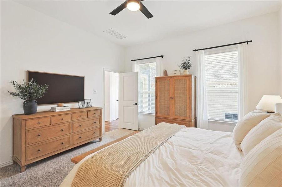 Carpeted bedroom featuring ceiling fan