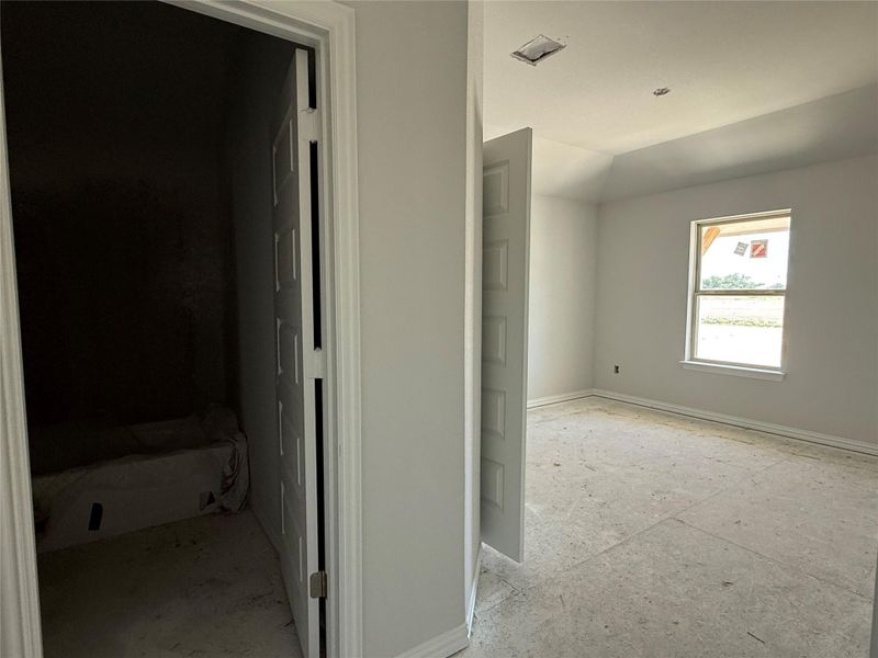 Hall featuring baseboards and vaulted ceiling Hall featuring baseboards and vaulted ceiling