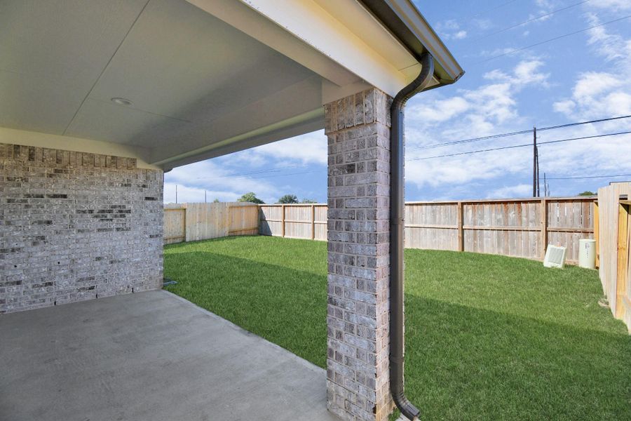 Experience outdoor living at its finest on this expansive covered patio, thoughtfully designed for BBQs and delightful outdoor dining. Sample photo of completed home with similar floor plan. Actual colors and selections may vary.
