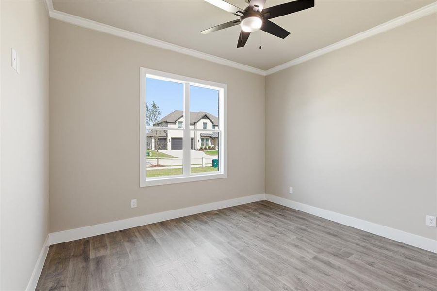 Neutral-toned interior featuring wood-finish flooring and a ceiling fan with integrated lighting