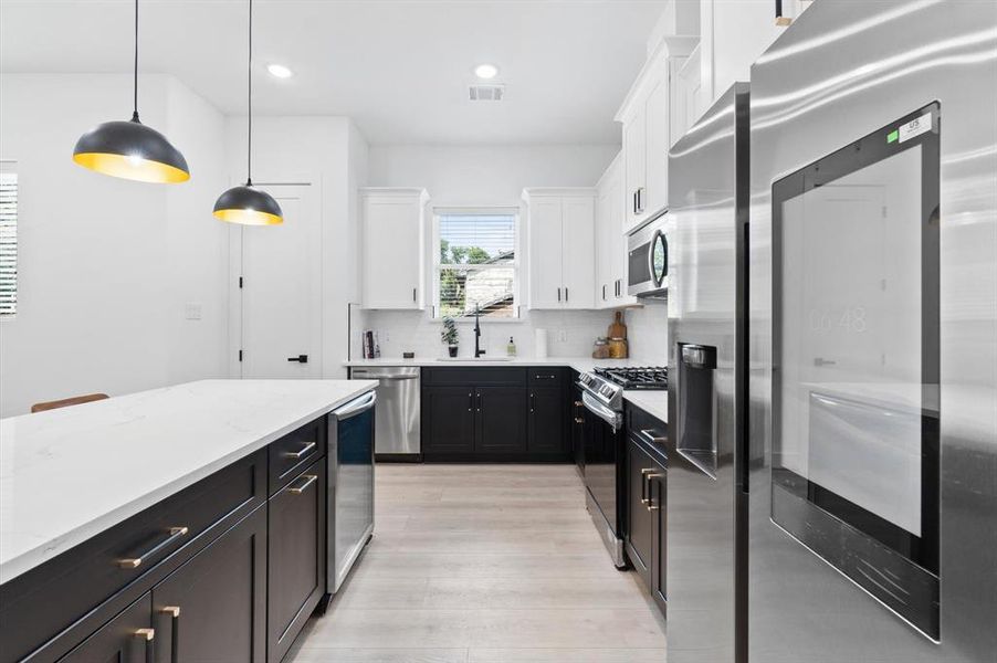 Kitchen with quartz counters, self- closing drawers and cabinets,  large peninsula - perfect for meal prep and entertaining