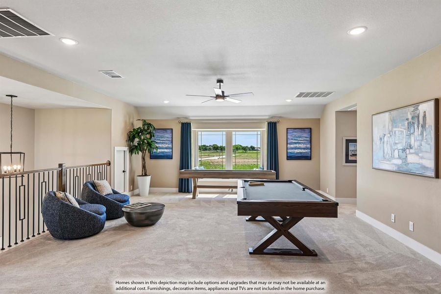 Upstairs game room with pool table, seating area, carpet flooring, and ceiling fan near open staircase railing Upstairs game room with pool table, seating area, carpet flooring, and ceiling fan near open staircase railing