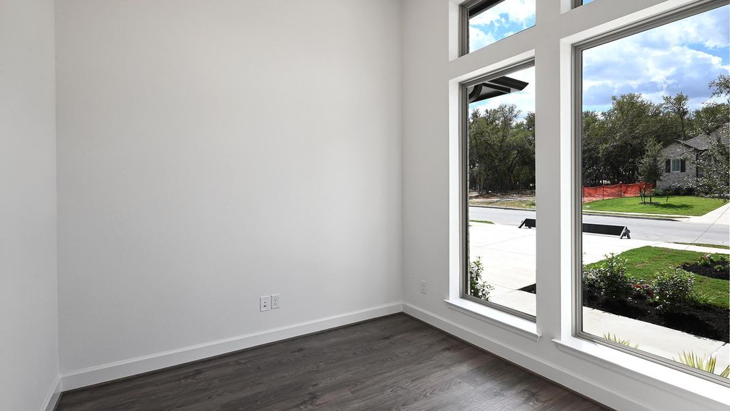 Empty room with baseboards and dark wood-style flooring