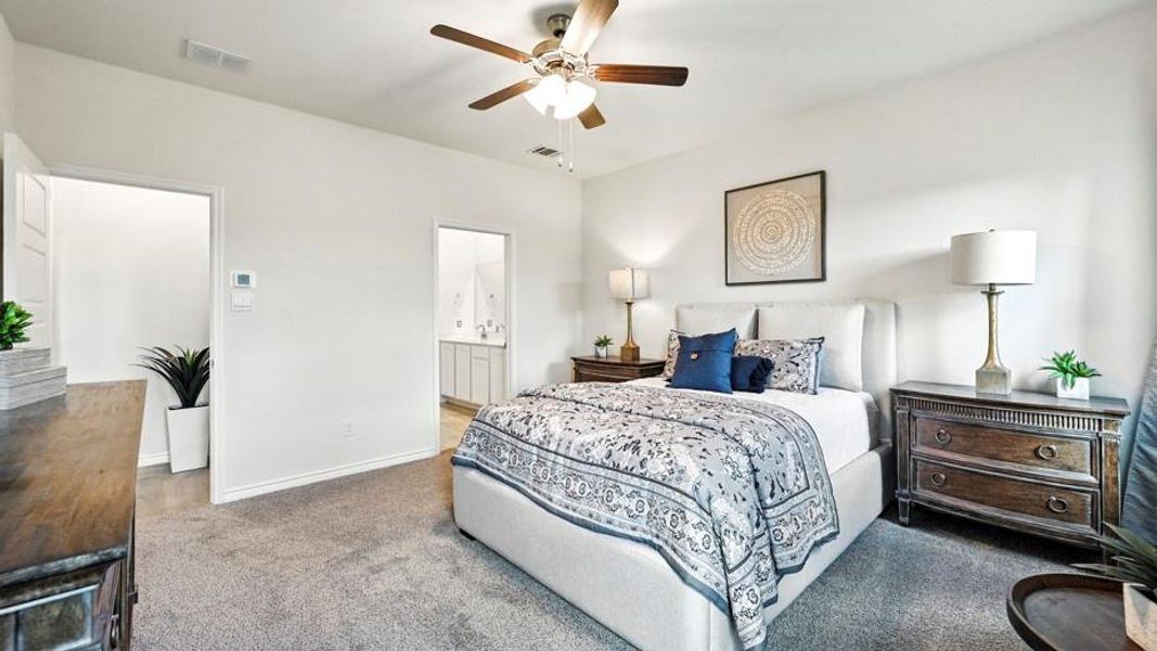 The property features a bedroom with neutral carpeting, a ceiling fan, and access to a bathroom with a double vanity