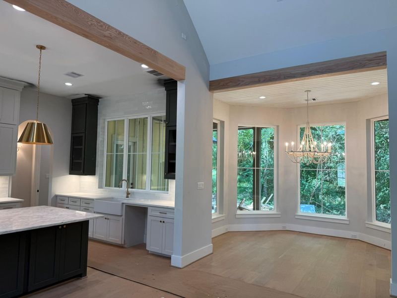 Kitchen featuring light wood-style floors, a chandelier, decorative light fixtures, recessed lighting, and light stone counters