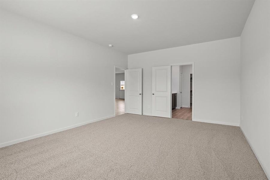 Unfurnished bedroom featuring light carpet and connected bathroom Unfurnished bedroom featuring light carpet and connected bathroom
