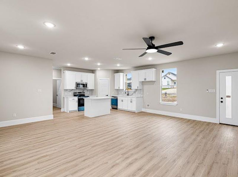 Unfurnished living room with light wood-style floors, a ceiling fan, and recessed lighting Unfurnished living room with light wood-style floors, a ceiling fan, and recessed lighting