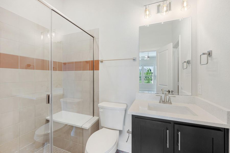 Bathroom with glass walk-in shower, dark vanity with white countertop, and large mirror Bathroom with glass walk-in shower, dark vanity with white countertop, and large mirror