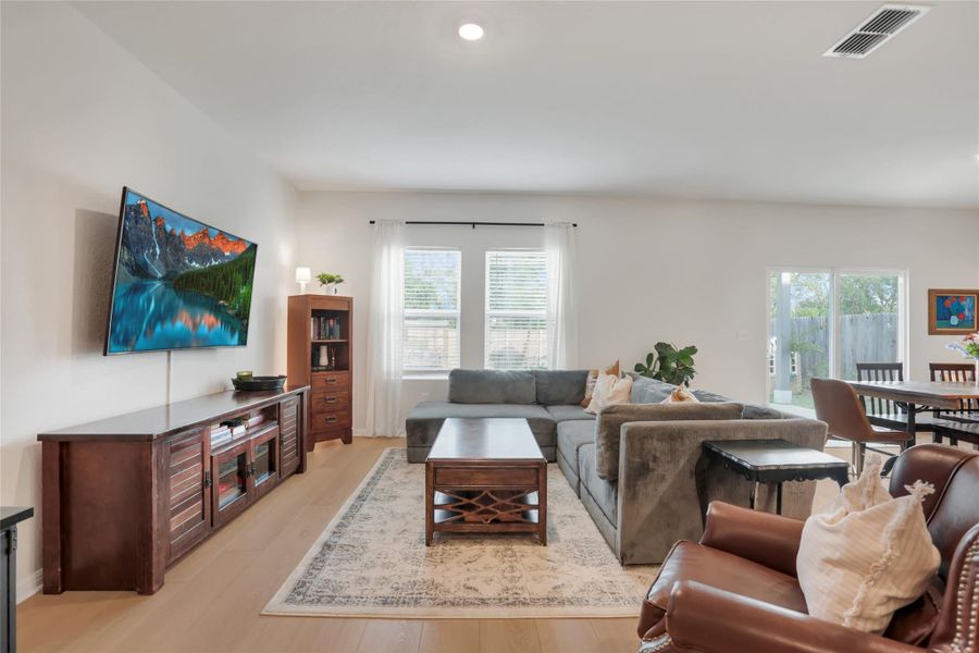 Living room featuring plenty of natural light, light wood-style flooring, and recessed lighting