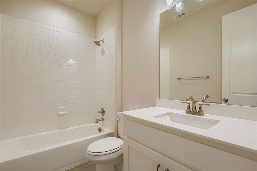 Bathroom featuring shower / tub combination, vanity, and tile patterned floors