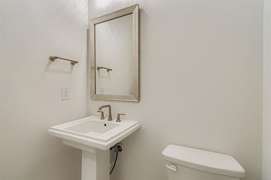 Half bathroom with toilet and a textured wall Half bathroom with toilet and a textured wall