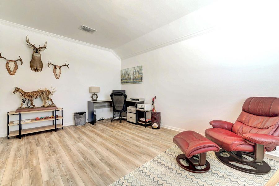 Office area featuring vaulted ceiling, wood finished floors, and ornamental molding