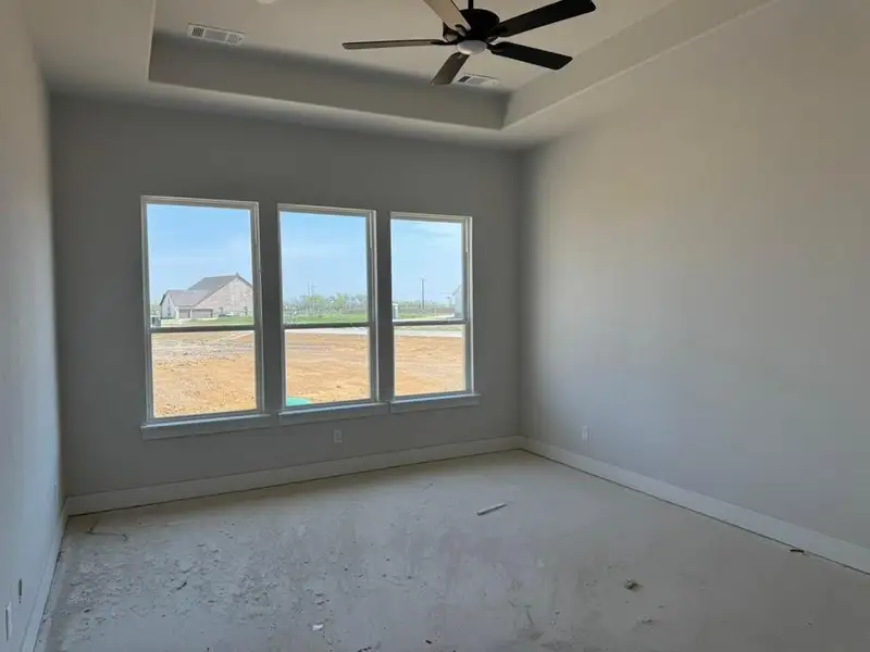 Empty room with a tray ceiling and a ceiling fan