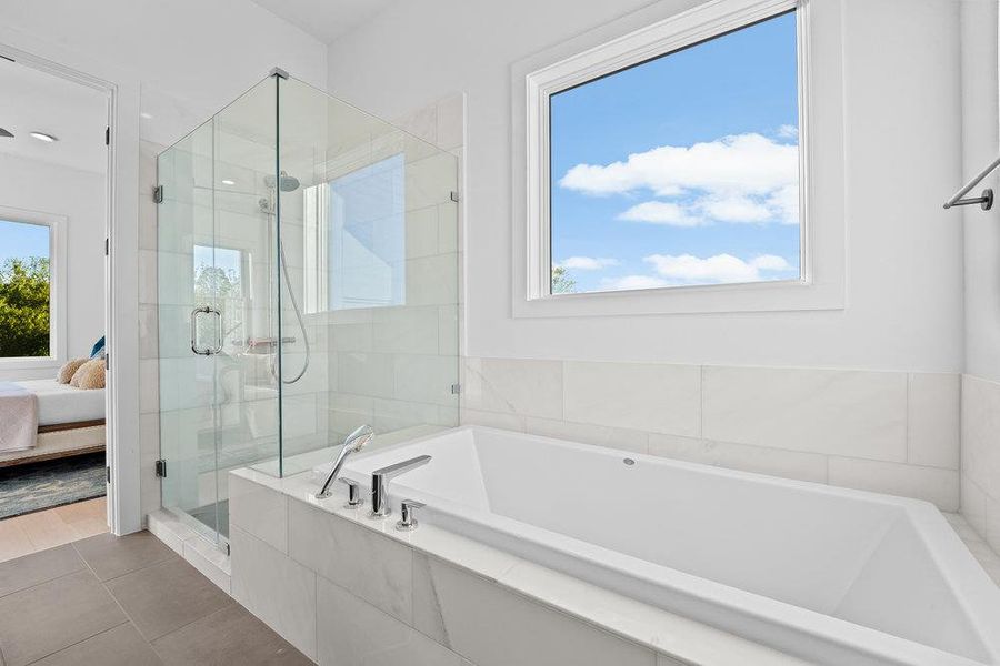 Ensuite bathroom featuring a garden tub, a shower stall, and tile patterned flooring