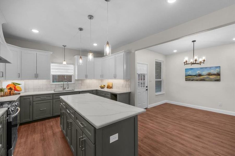 Kitchen featuring white cabinetry, sink, hanging light fixtures, a center island, and black / electric stove