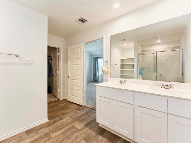 This photo showcases a spacious bathroom with a double vanity, and a walk in shower. This photo showcases a spacious bathroom with a double vanity, and a walk in shower.