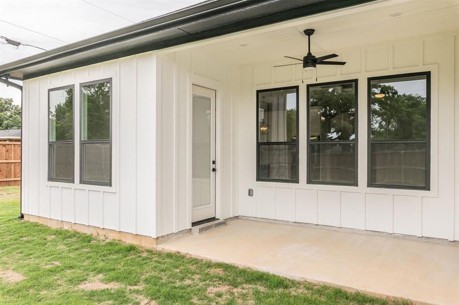 View of exterior entry featuring a ceiling fan, board and batten siding, and a patio area View of exterior entry featuring a ceiling fan, board and batten siding, and a patio area