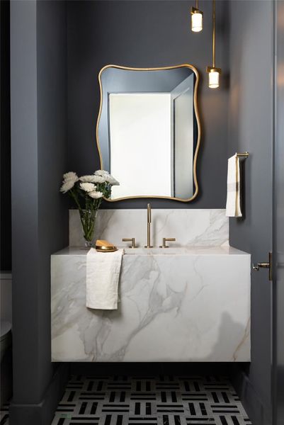 A designer powder room on the first floor showcases dramatic style and elegant finishes, offering a luxurious experience for guests. An additional half bath located outdoors provides convenient access for pool and patio use. A designer powder room on the first floor showcases dramatic style and elegant finishes, offering a luxurious experience for guests. An additional half bath located outdoors provides convenient access for pool and patio use.