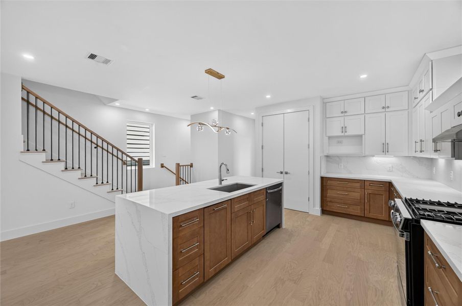 Spacious kitchen with plenty of storge space featuring beautiful natural duo toned custom cabinets with brushed nickel hardware