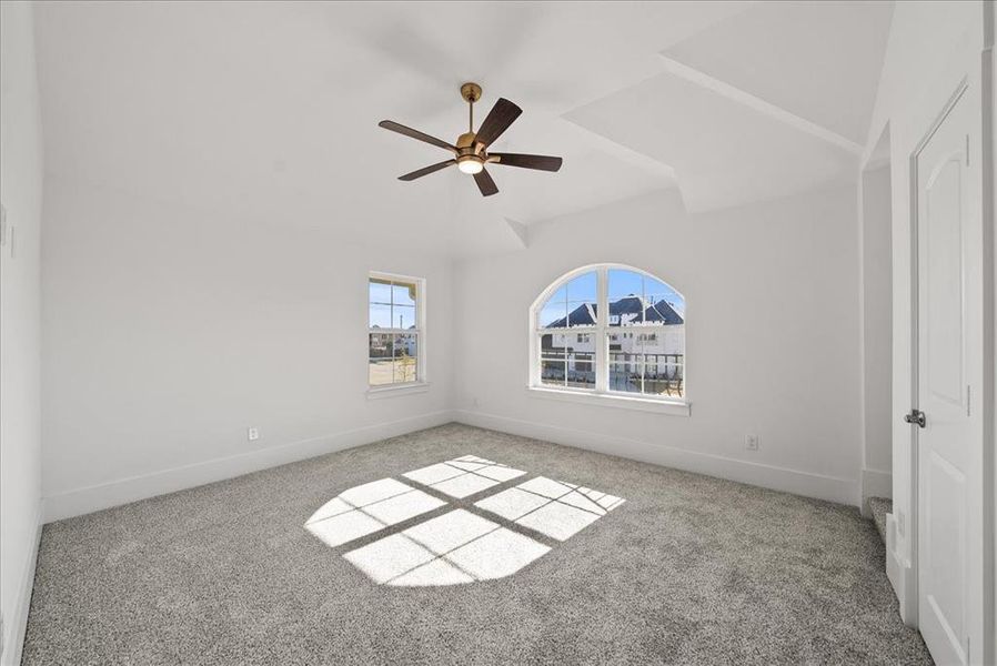 Carpeted bedroom featuring ceiling fan and natural light Carpeted bedroom featuring ceiling fan and natural light