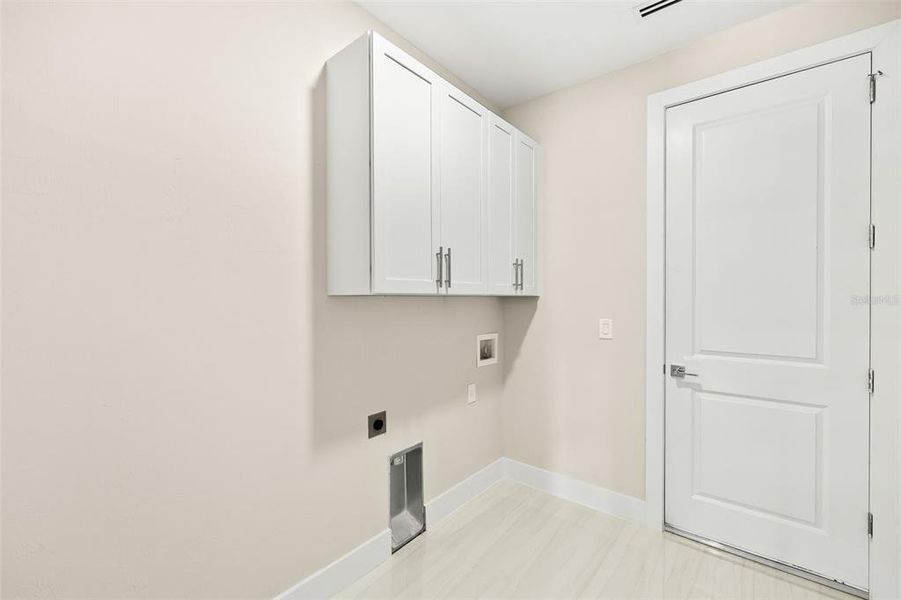 Inside laundry room with cabinets and washer/dryer hook up. Inside laundry room with cabinets and washer/dryer hook up.