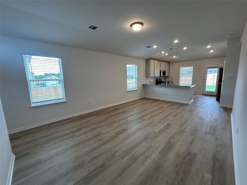 Unfurnished living room with dark wood-style flooring and recessed lighting Unfurnished living room with dark wood-style flooring and recessed lighting