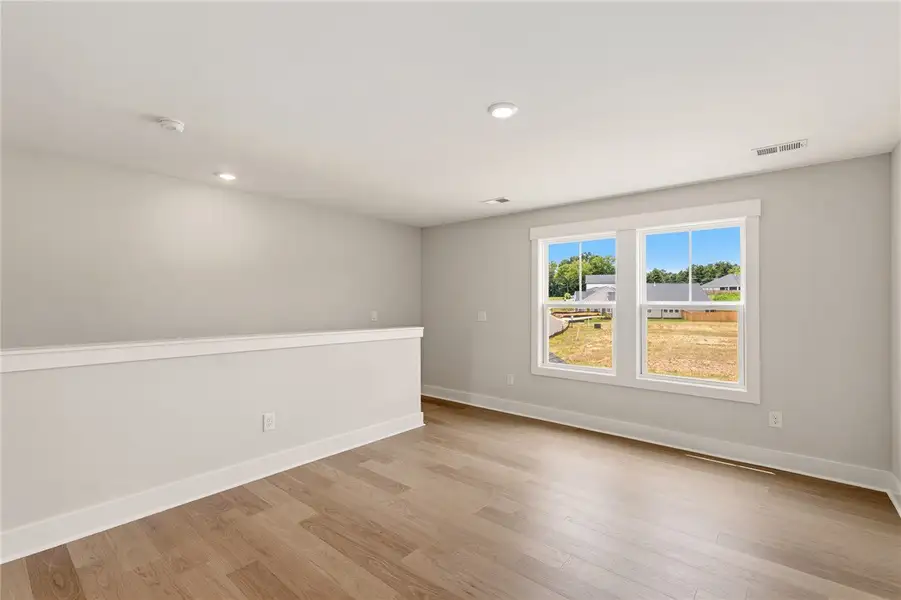 A versatile open loft space featuring warm wood fl
