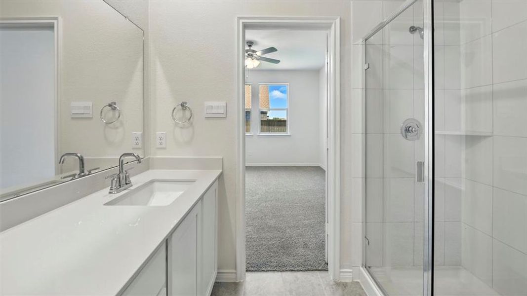 Full bathroom with vanity, a shower stall, light carpet, and ceiling fan