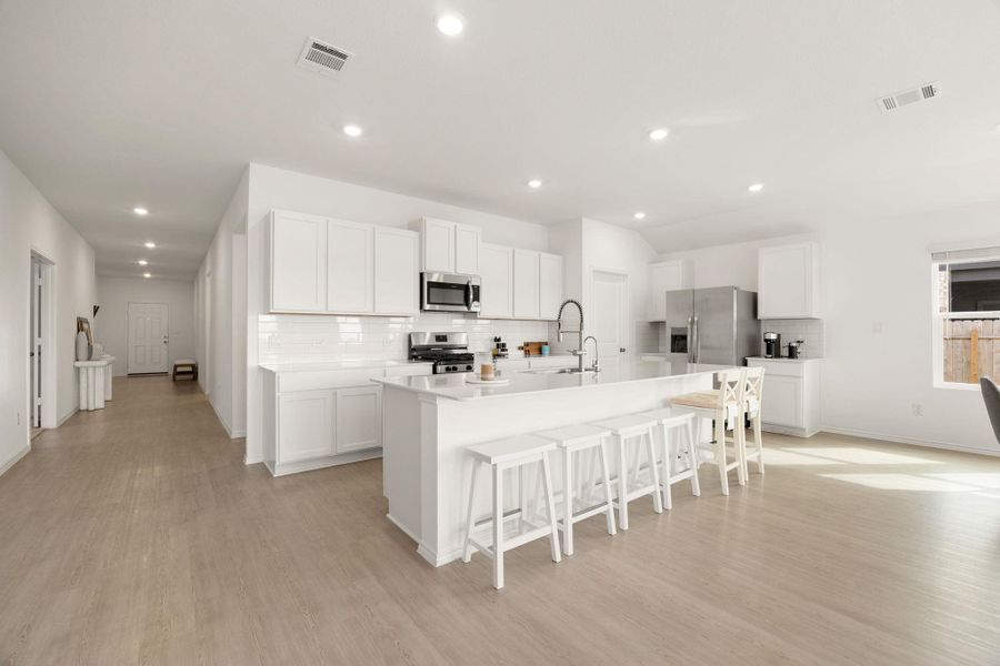 An open concept kitchen features abundant counter space and integrated stainless appliances, ideal for culinary creations.