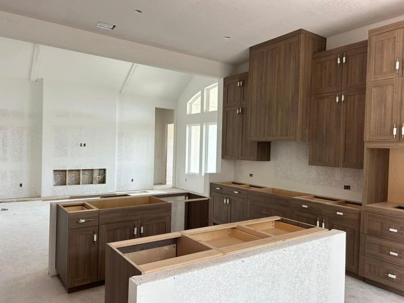 Kitchen with a kitchen island, extractor fan, and brown cabinetry Kitchen with a kitchen island, extractor fan, and brown cabinetry