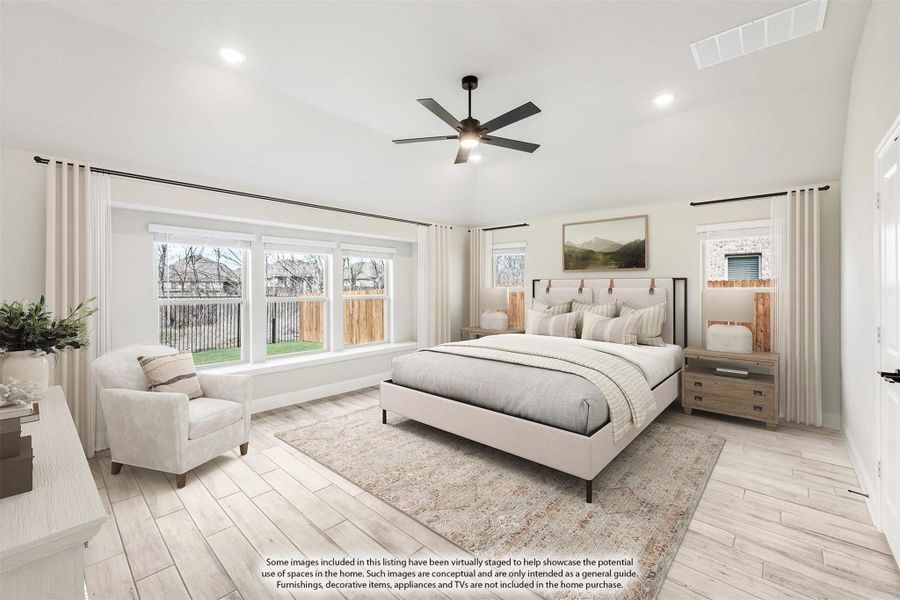 Spacious master bedroom with light wood floors, ceiling fan, large windows, and neutral decor