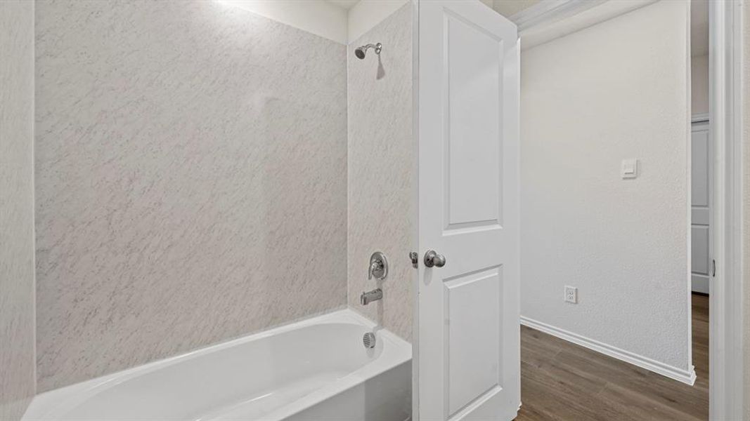 Full bathroom featuring shower / washtub combination and dark wood-style flooring