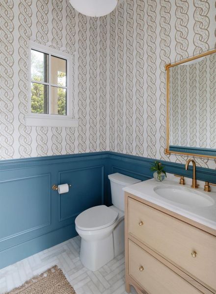 Powder bath on main floor includes wainscot treatment with designer wallpaper.