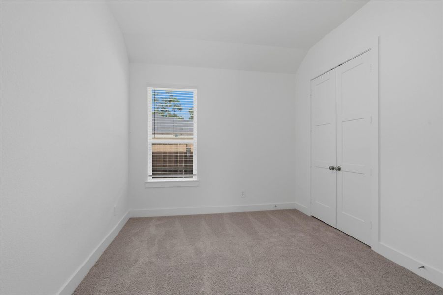 Perfect for guests or a quiet home office, this room features soft plush carpeting, a window with fitted blinds, sloped ceiling, and ample sized closet space. Perfect for guests or a quiet home office, this room features soft plush carpeting, a window with fitted blinds, sloped ceiling, and ample sized closet space.