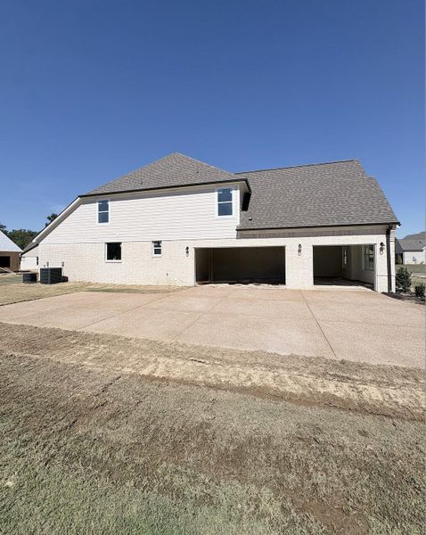 Light brick exterior with white siding, covered parking area, concrete driveway, and a shingle roof Light brick exterior with white siding, covered parking area, concrete driveway, and a shingle roof