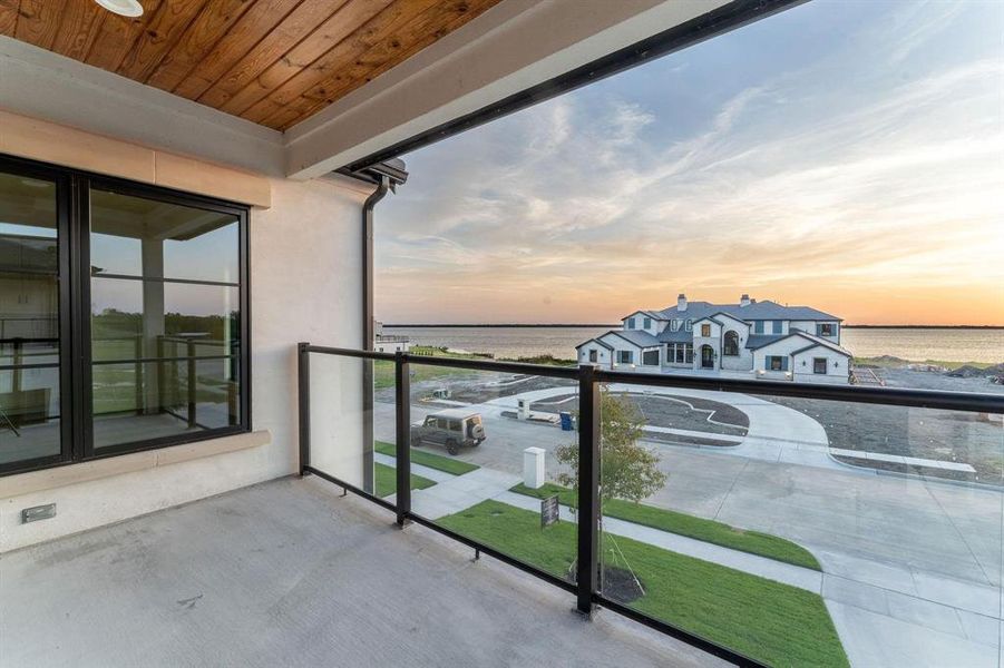 Balcony at dusk featuring a water view