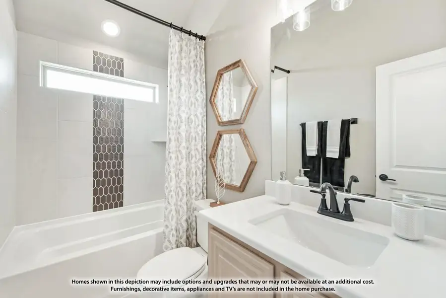 Bathroom with white vanity, tub-shower combo with dark hex tile accent, and hexagon wood-framed mirrors Bathroom with white vanity, tub-shower combo with dark hex tile accent, and hexagon wood-framed mirrors