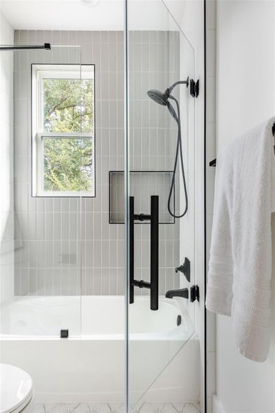 Refined touches throughout, including a window for natural light, complement the versatile shower and tub combo with a removable showerhead, offering both functionality and elegance.