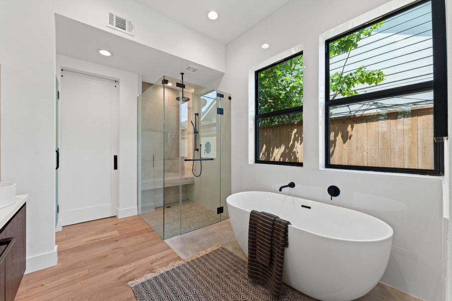 A deep soaking tub and oversize rainfall shower invite you to linger longer, surrounded by curated modern textures.