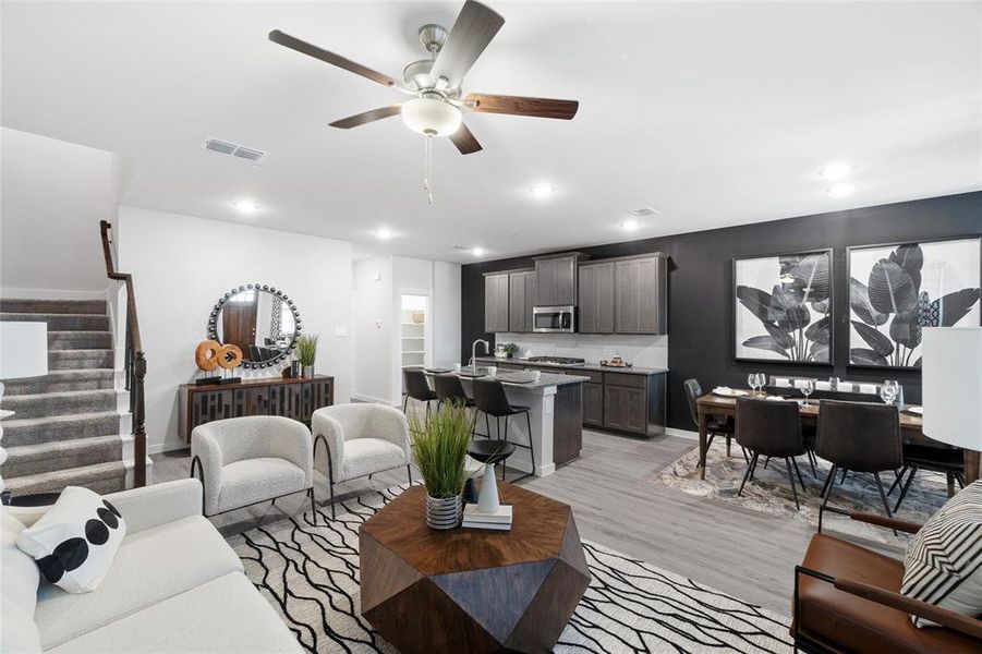 Living room with light wood-type flooring, sink, and ceiling fan