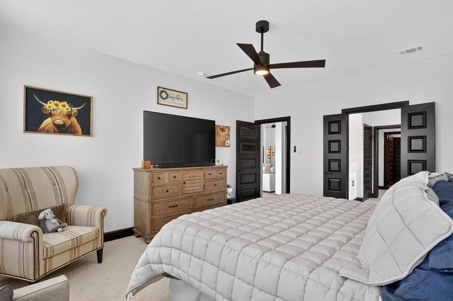 Spacious interior room with white walls, dark trim, and light carpet flooring